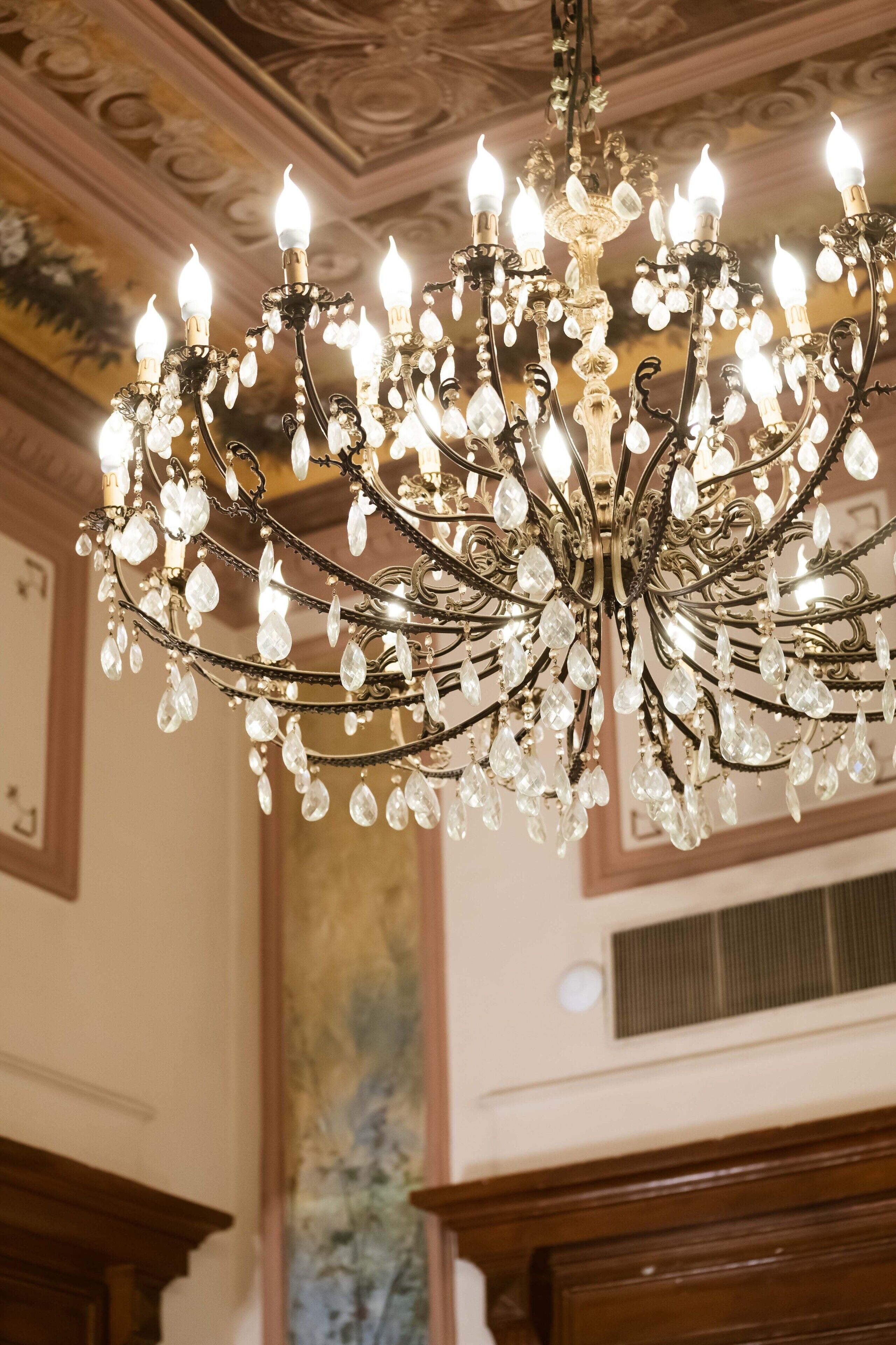 A chandelier with multiple arms and crystal decorations.