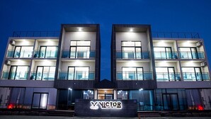 Un hôtel moderne à la façade symétrique, doté de nombreux balcons et d’une entrée imposante.