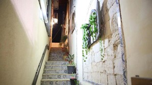 A narrow stairway with patterned tiles leading to a landing. - Daher Guest House Nazareth - Hostel (Nazareth)