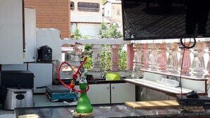 A modern kitchen with a built-in TV, a green water dispenser, and a coffee machine. - Daher Guest House Nazareth - Hostel (Nazareth)