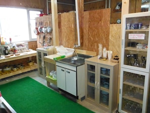 A kitchen with wooden cabinets, a sink, and various kitchen utensils.