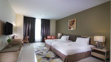 Quarto de hotel com duas camas, uma escrivaninha, uma televisão e uma janela grande com cortinas.