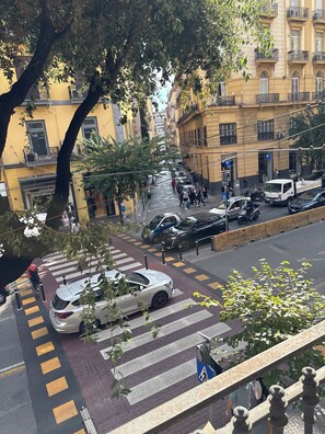 A street view with a pedestrian crossing, parked cars, and buildings with balconies. - B&B 248 (Naples)
