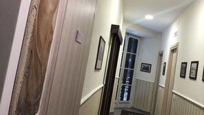 A hallway with a door on the left, a patterned rug on the floor, and a framed picture on the wall. - B&B 248 (Naples)