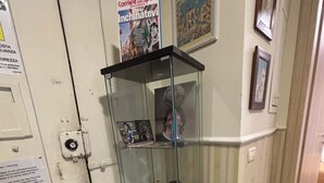 A glass display case with various items, a door with a sign, and a wall with a framed picture. - B&B 248 (Naples)