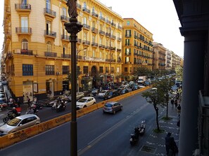 A busy urban street with yellow buildings, parked cars, and motorcycles. - B&B 248 (Naples)