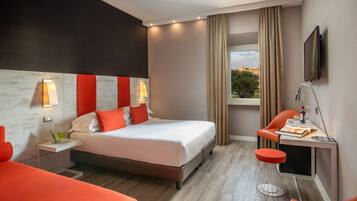 Une chambre d’hôtel moderne dotée d’un grand lit, d’un bureau avec une chaise, d’un téléviseur fixé au mur et d’une fenêtre avec des rideaux.