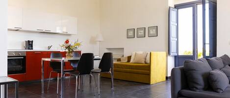 A modern living space with a kitchen, dining area, and seating area.