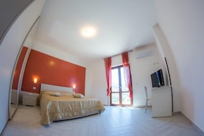 A bedroom with a bed, a TV, and a desk. - Agriturismo L'Oasi (Ceraso)