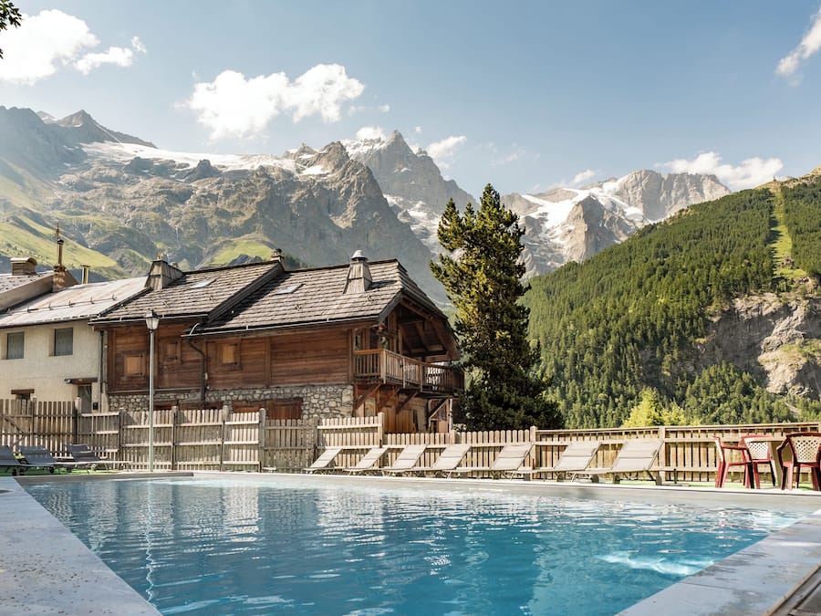 Een buitenzwembad, ligstoelen bij het zwembad