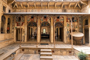 Un edificio histórico con arcos ornamentados y frescos detallados.
