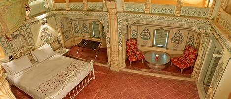 A room with a bed, a small table, and two chairs.