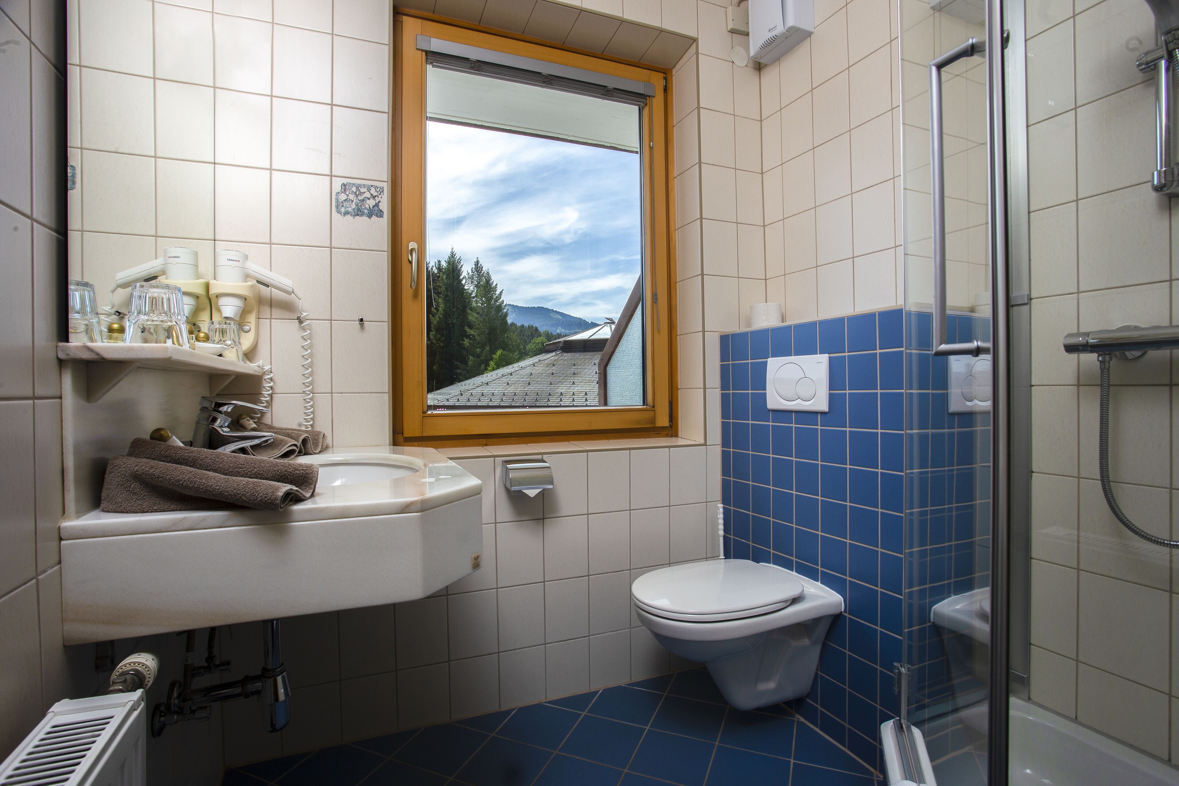 A bathroom with a toilet, sink, and shower.