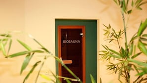 Una puerta con la leyenda "Biosana", un marco verde, rodeada de plantas de bambú.