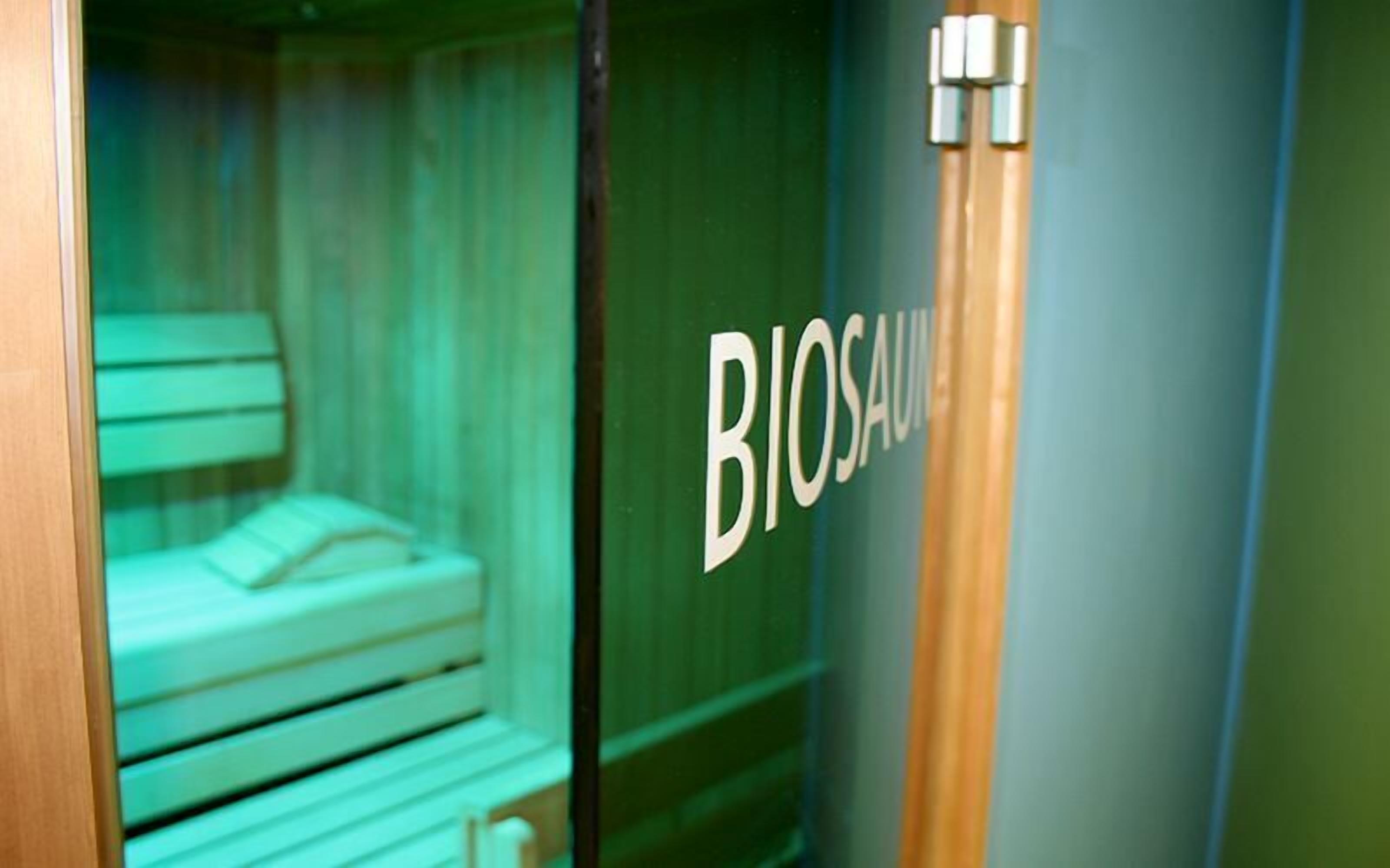 A room with a bed and a door labeled "BIOSAU".