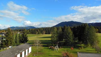 Paisaje rural con una construcción de techo inclinado y un pequeño jardín.
