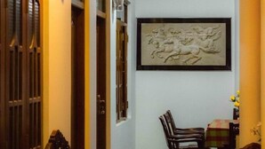 A narrow hallway with wooden doors and a framed artwork on the wall. - Sameera Villa (Weligama)
