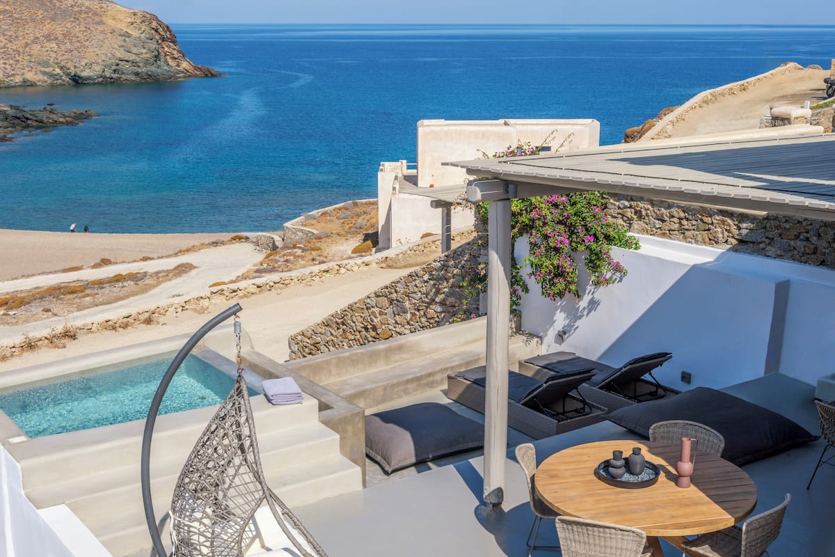 Una terrazza sul tetto con piscina, posti a sedere all'aperto e vista mare.