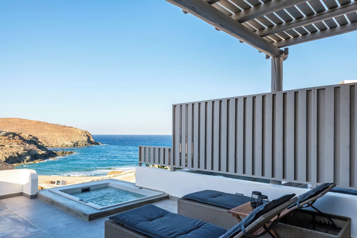 Una terrazza panoramica sul tetto con vasca idromassaggio e mobili in vimini.