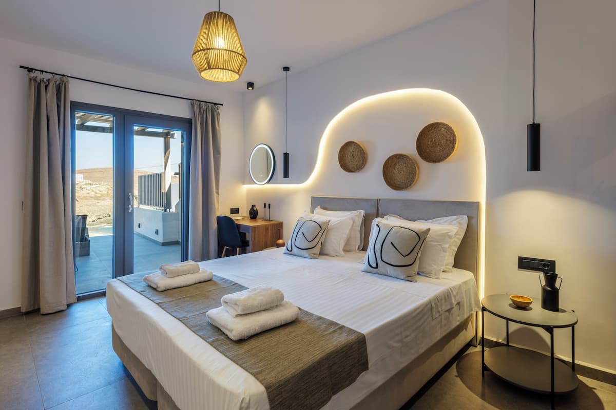 Una camera d'albergo moderna con un letto grande, una scrivania e vista sull'esterno.