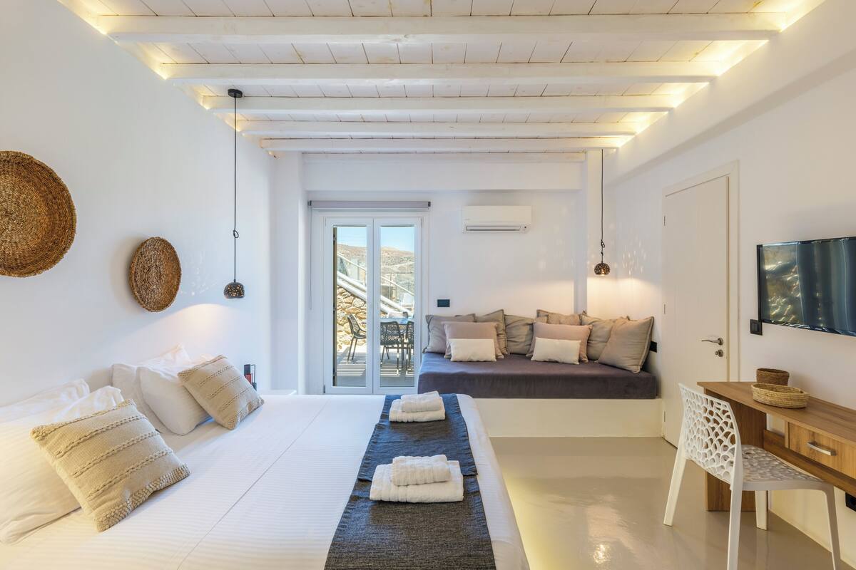 Una camera da letto moderna con un grande letto, una scrivania e un televisore.