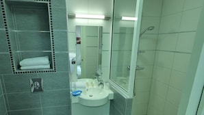 A modern bathroom with a toilet, sink, and shower. - Hotel Palym (Biarritz)
