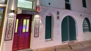 A hotel facade with a prominent 'PALYM' sign, a balcony with railings, and a green neon sign above the entrance. - Hotel Palym (Biarritz)