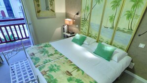A hotel room with a bed, a nightstand, a lamp, a balcony, and a view of the outside. - Hotel Palym (Biarritz)