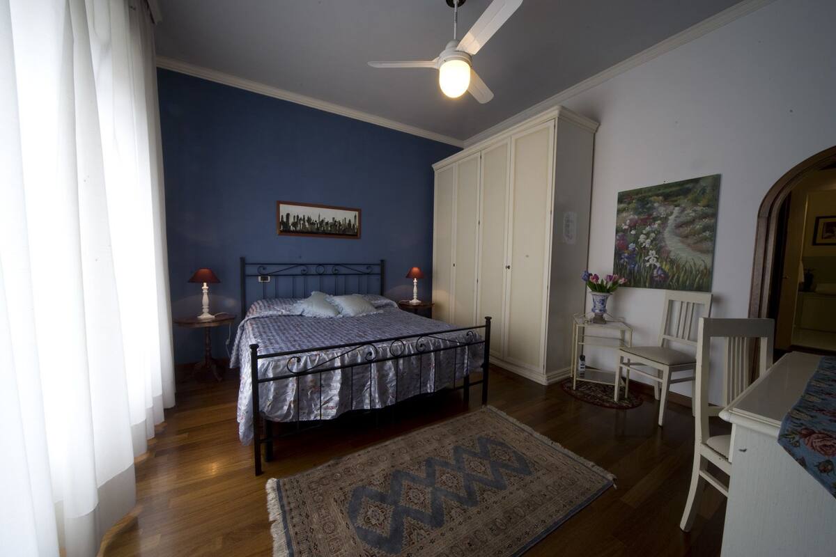 Una camera da letto con un letto, un armadio, una scrivania e una sedia.