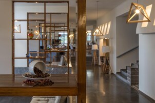Un interior moderno con una mesa de madera que muestra granos de café y flores secas.