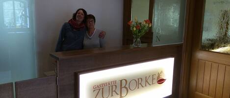 A reception desk with a sign reading "Gaststätte Zur Borke".