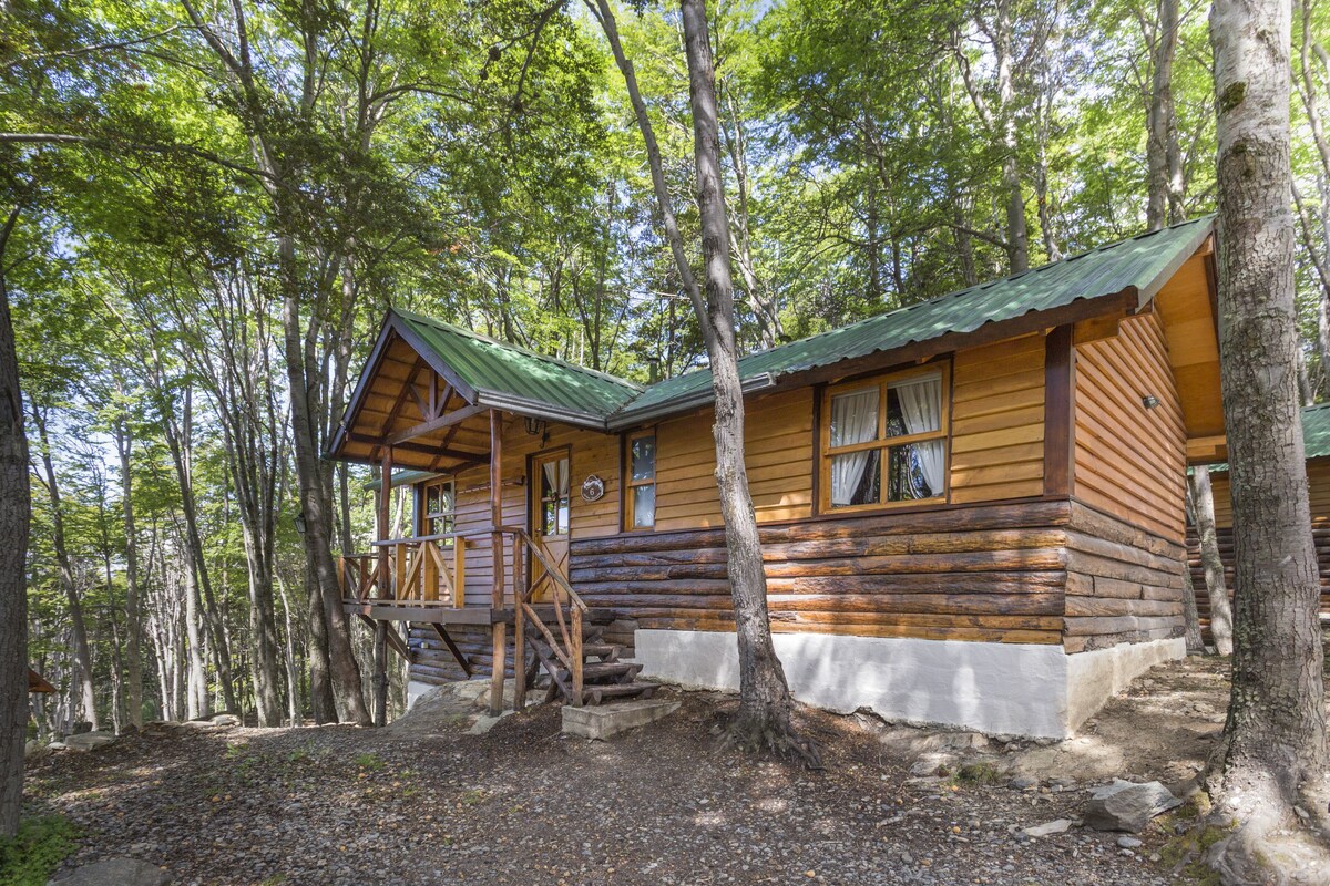 A log cabin with a porch and a staircase leading to the entrance.