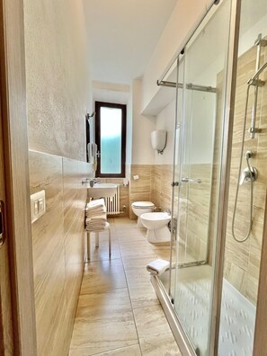 Klassieke driepersoonskamer | Badkamer | Een douche, gratis toiletartikelen, een haardroger, een bidet