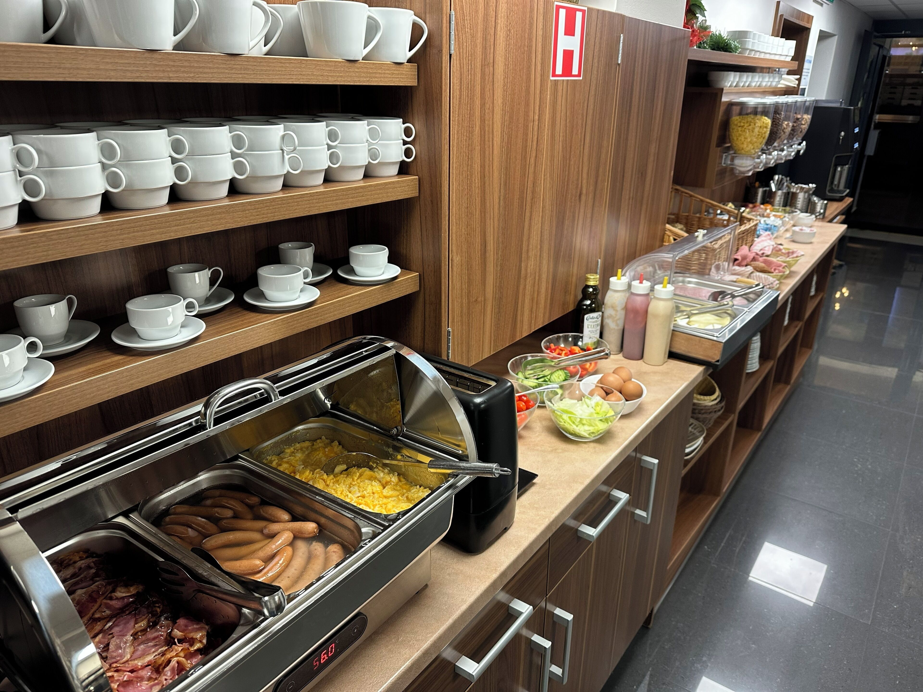 A buffet area with various food options, including meats, eggs, and salads.