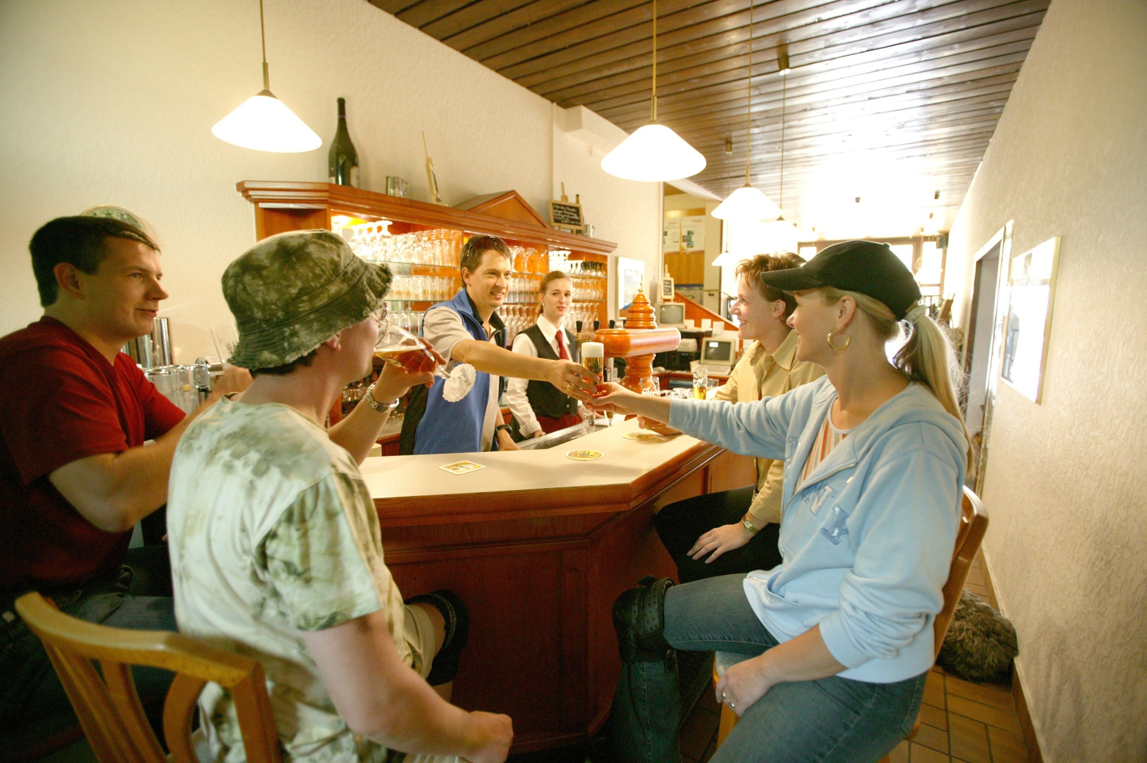 A bar area with wooden counters and hanging pendant lights.