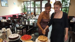 A dining area with multiple tables, chairs, and a variety of desserts on display. - Hotel Pinger (Remagen)