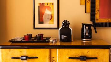 Une petite cuisine équipée d’une machine à café, d’une bouilloire et d’un plateau avec des tasses et une théière.