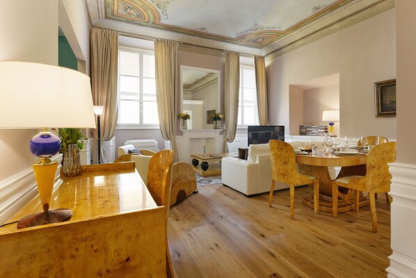 A dining area with a wooden table, chairs, and a television. - La Maison du Sage (Florence)