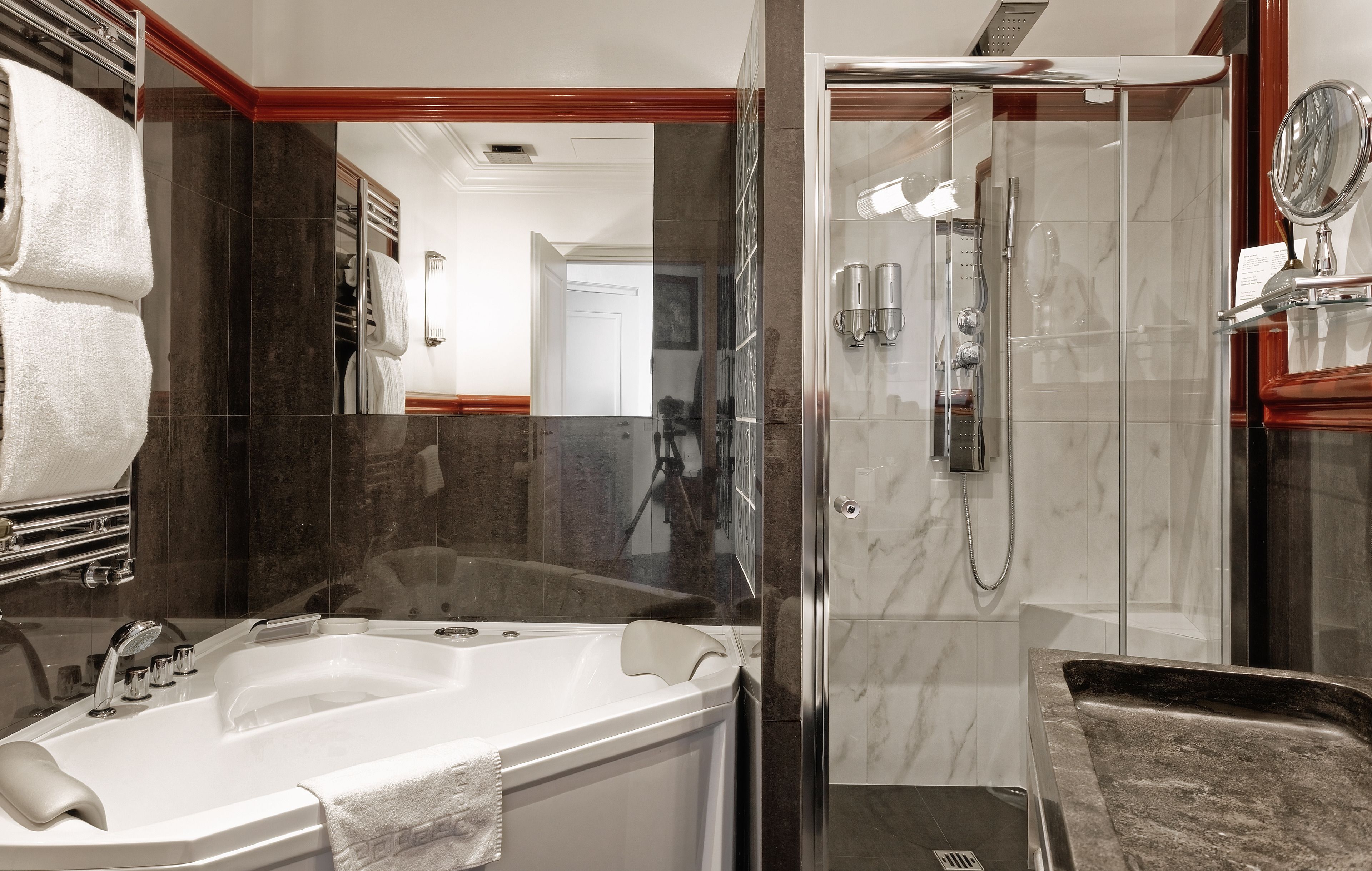 A modern bathroom with a bathtub, shower, and vanity.