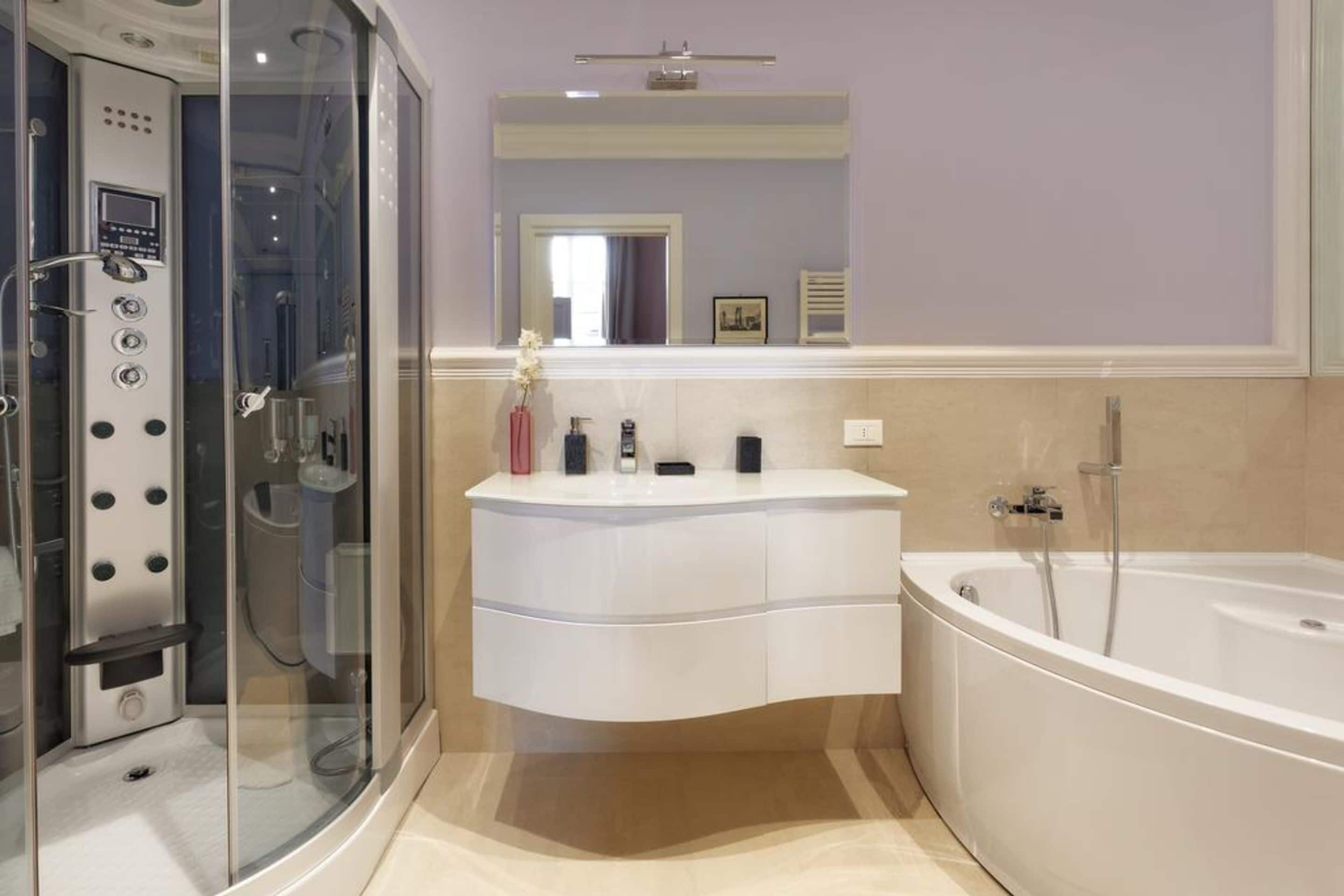 Ein modernes Badezimmer mit einer Duschkabine, einem Schminktisch mit Spiegel und einer freistehenden Badewanne.