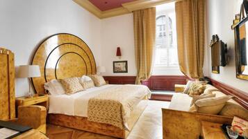 Une chambre d’hôtel avec un grand lit, des meubles en bois, une fenêtre avec des rideaux et une vue sur la ville.