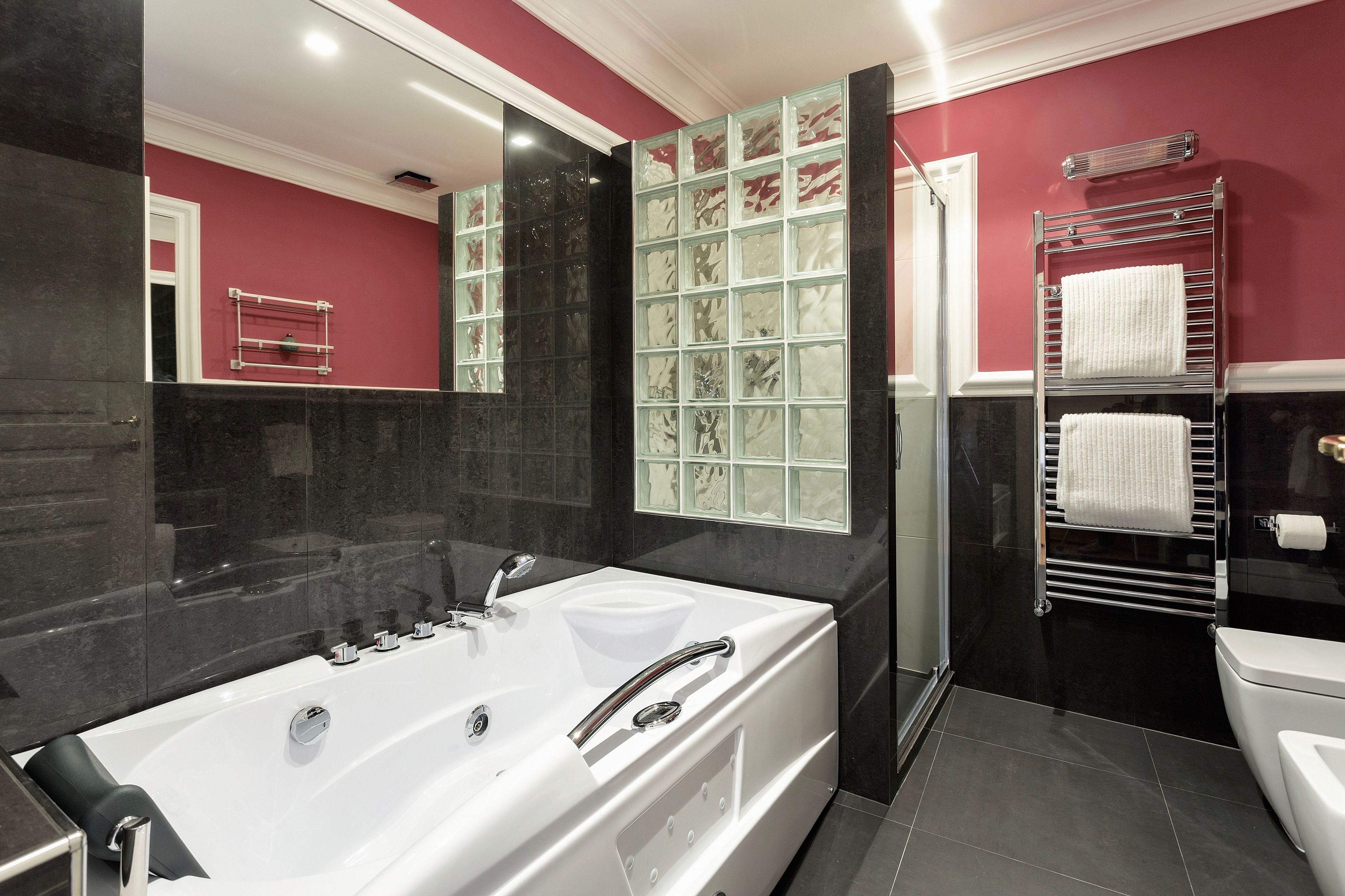 A modern bathroom with a large bathtub, a glass shower enclosure, and a white toilet.