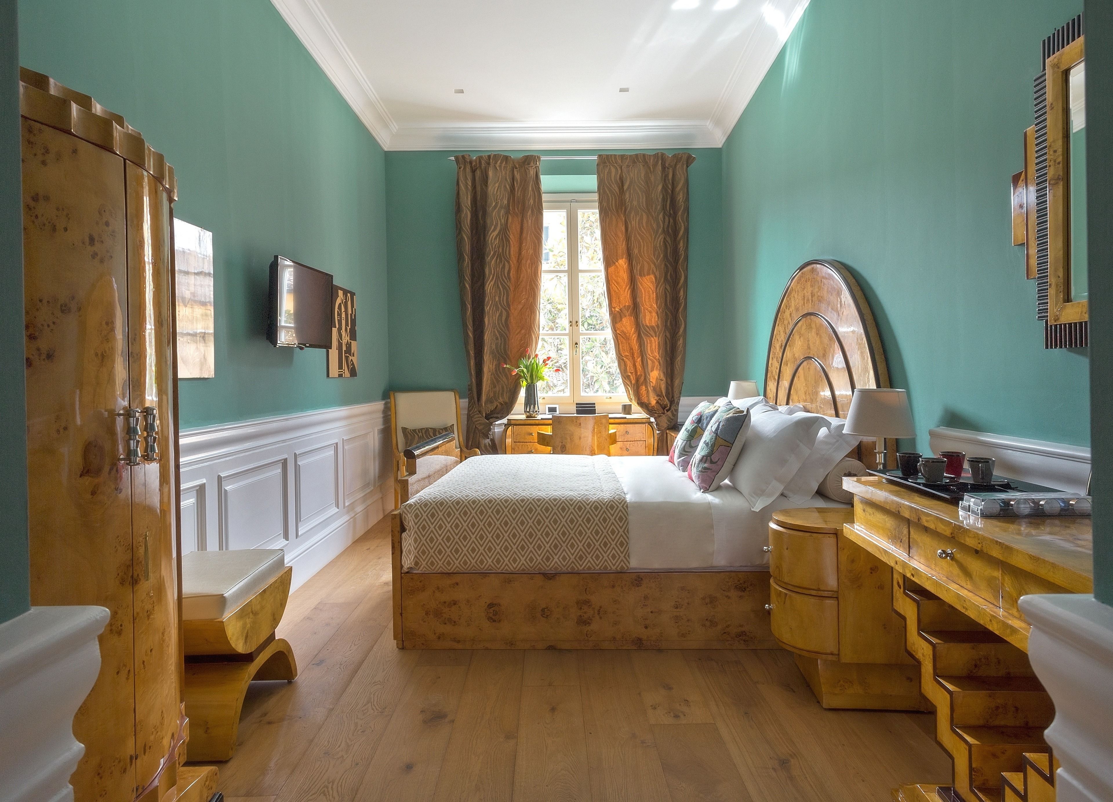 A bedroom with a wooden bed, a wooden dresser, a desk, and a mirror.