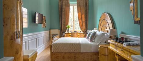 A bedroom with a wooden bed, a wooden dresser, a desk, and a mirror.