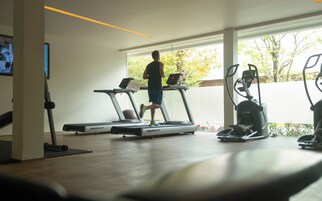 Uma academia com esteiras e equipamentos de ginástica.