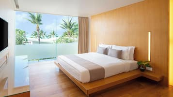 Une chambre d’hôtel moderne dotée d’un grand lit, d’une télévision, d’un bureau en bois et d’un balcon offrant une vue sur des palmiers et une piscine.