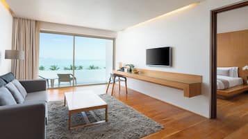 Une chambre d’hôtel moderne dotée d’une grande fenêtre, d’un téléviseur à écran plat, d’un canapé, d’un bureau et d’un lit.