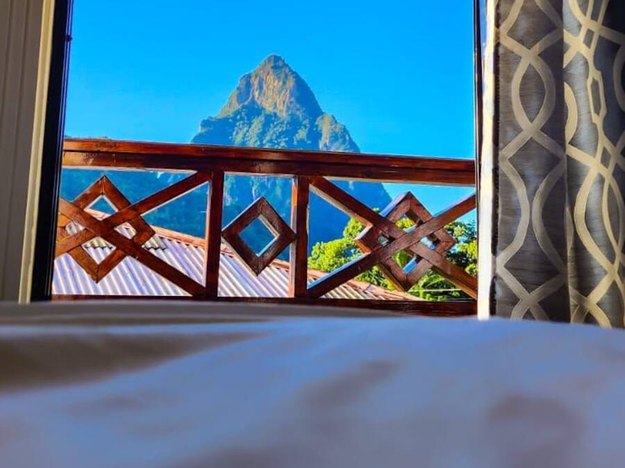 A balcony with a view of a mountain and a patterned curtain.