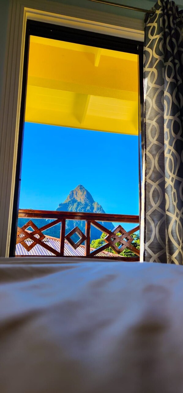 Un balcón con vista a una montaña y una cortina estampada.