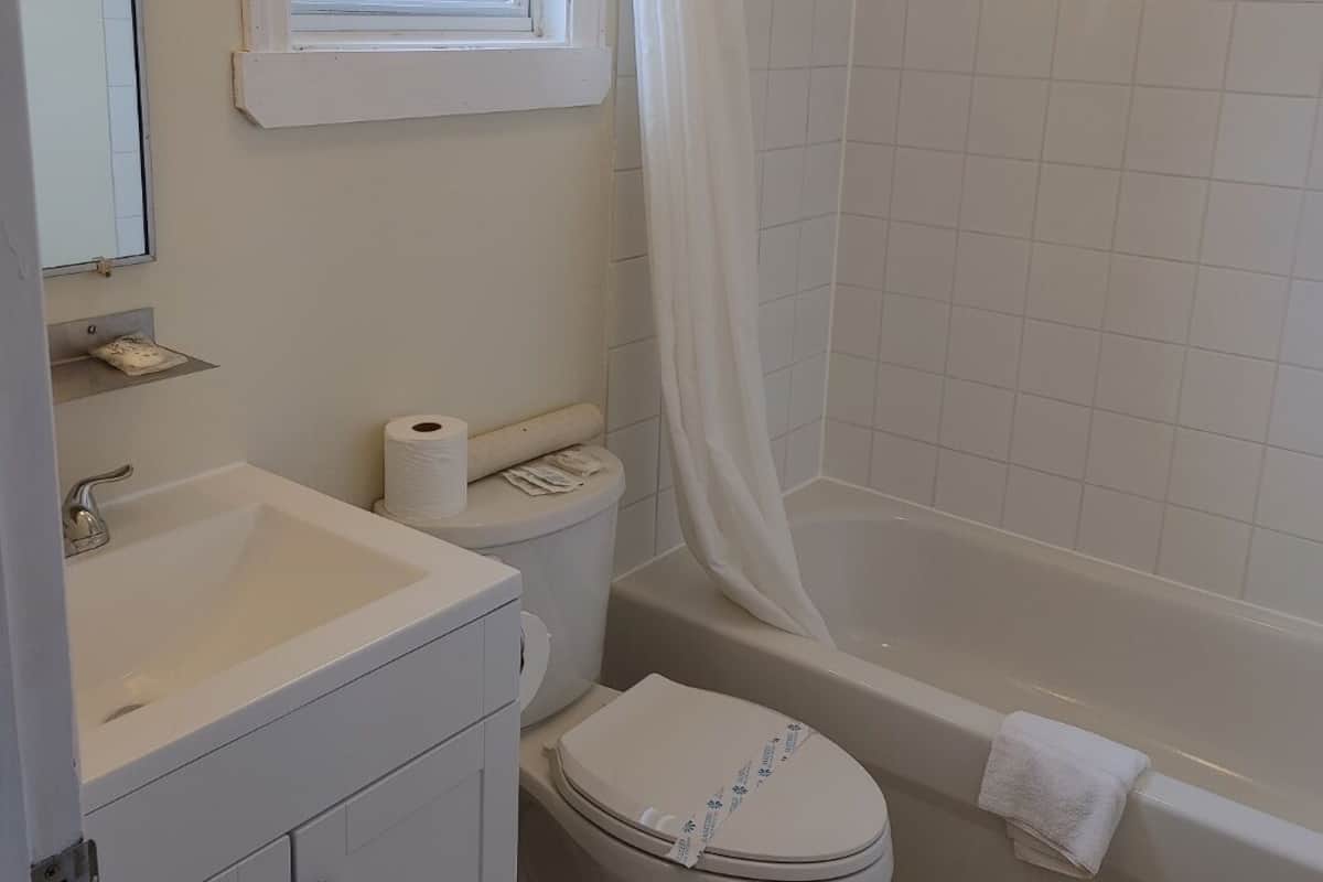 A bathroom with a toilet, sink, and bathtub.